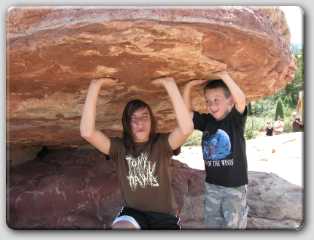 Shelby & Cody holding up one of the rock formations at Garden of the Gods.